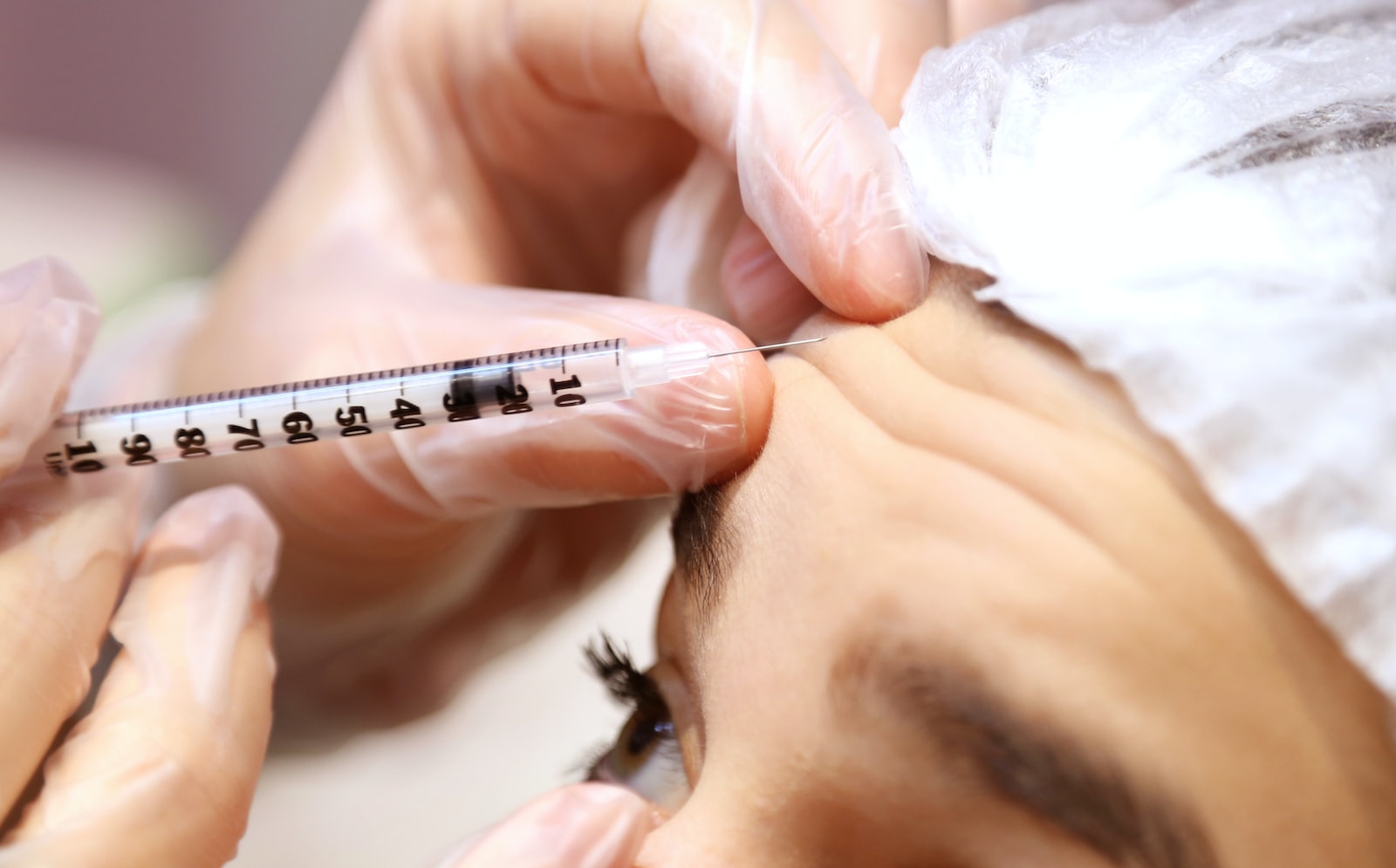 a woman getting her eyebrows examined by a doctor